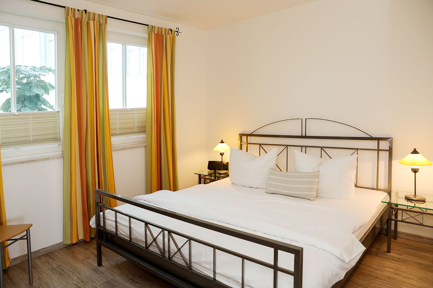 Schlafzimmer mit Doppelnett und Fenster mit Vorhängen